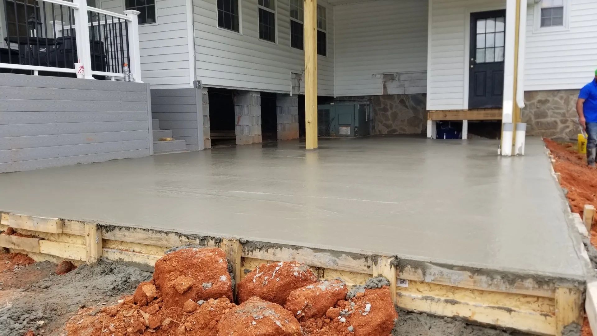 A concrete patio is being built in front of a house