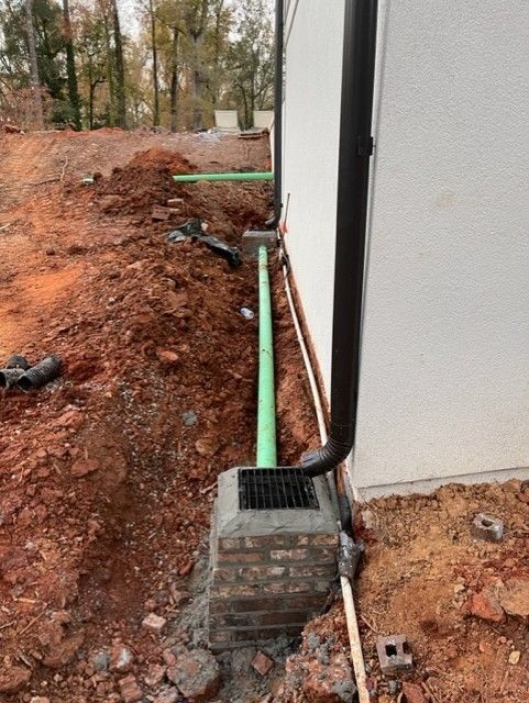 a green pipe is being installed on the side of a building