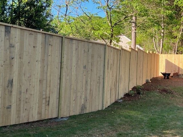 a wooden fence is sitting in the middle of a lush green yard
