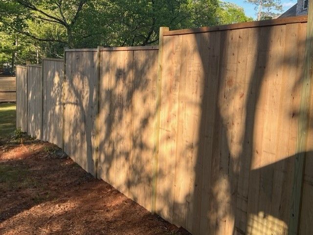 a wooden fence surrounded by trees in a backyard