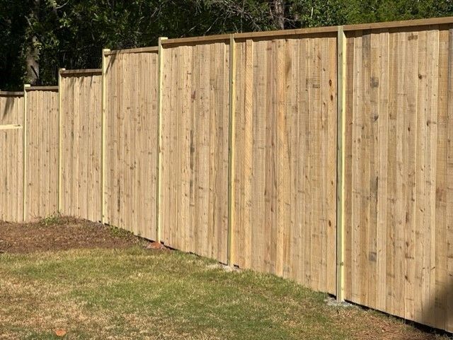 a wooden fence is sitting on top of a lush green lawn