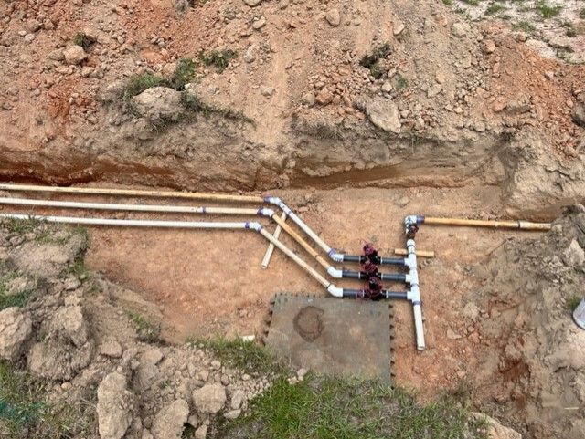 a bunch of pipes are laying in the dirt .