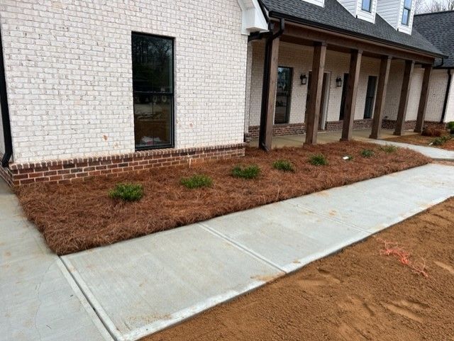 a white brick house with a concrete walkway in front of it