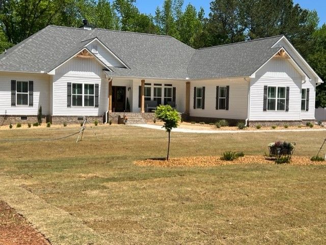 a large white house with a gray roof and black shutters