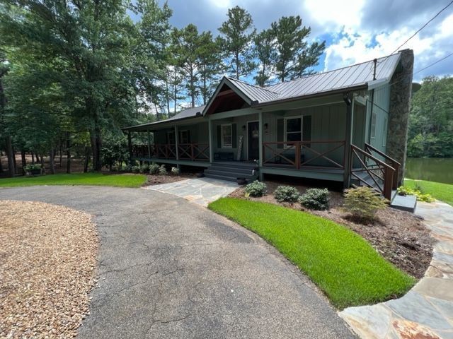 a house with a porch and a driveway in front of it