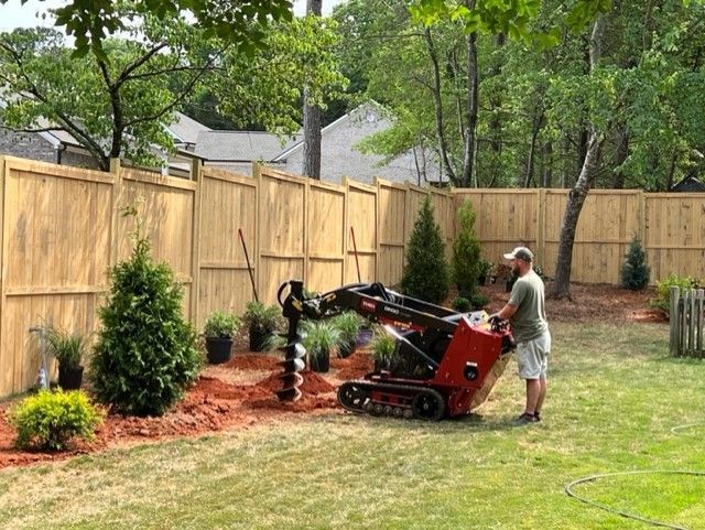 a man is standing next to a machine in a backyard