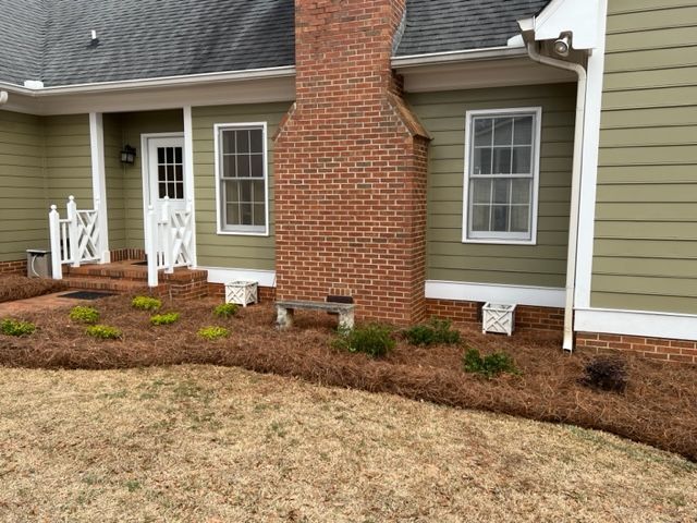 the front of a house with a brick chimney and a green siding