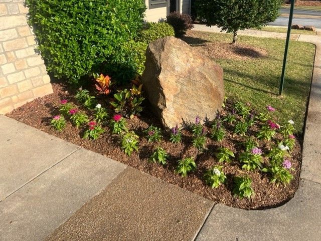 there is a large rock in the middle of the garden