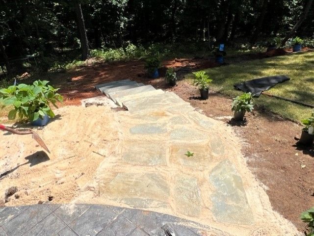 a stone walkway is being built in a backyard
