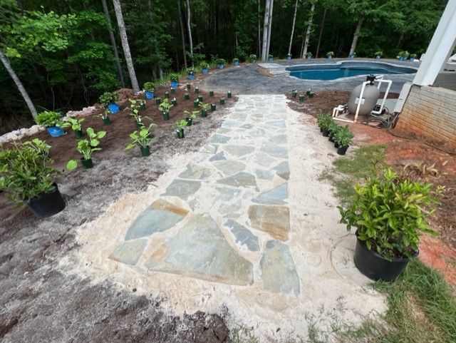 a stone walkway leading to a pool in a backyard