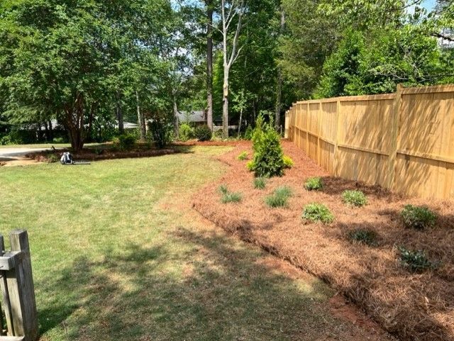 a wooden fence surrounds a lush green yard