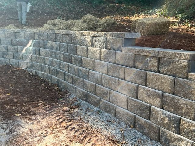 a brick wall is being built in a dirt field