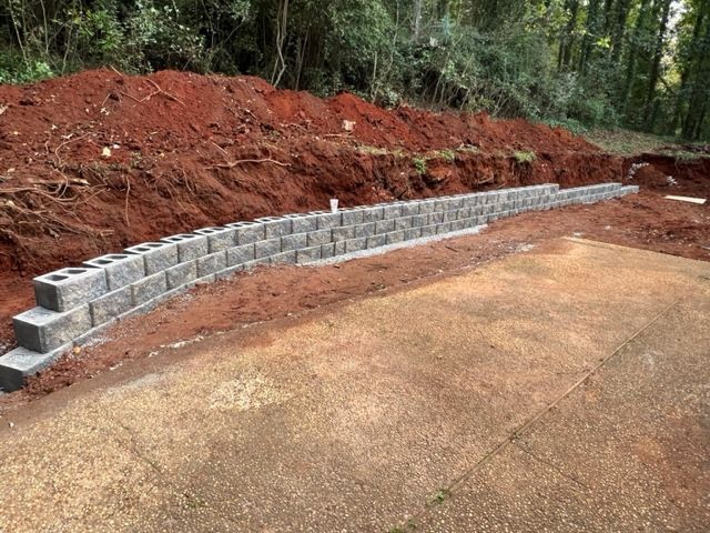 a brick wall is being built on top of a dirt hill