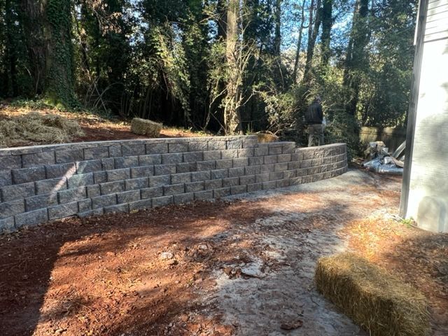 a brick wall is being built in the backyard of a house