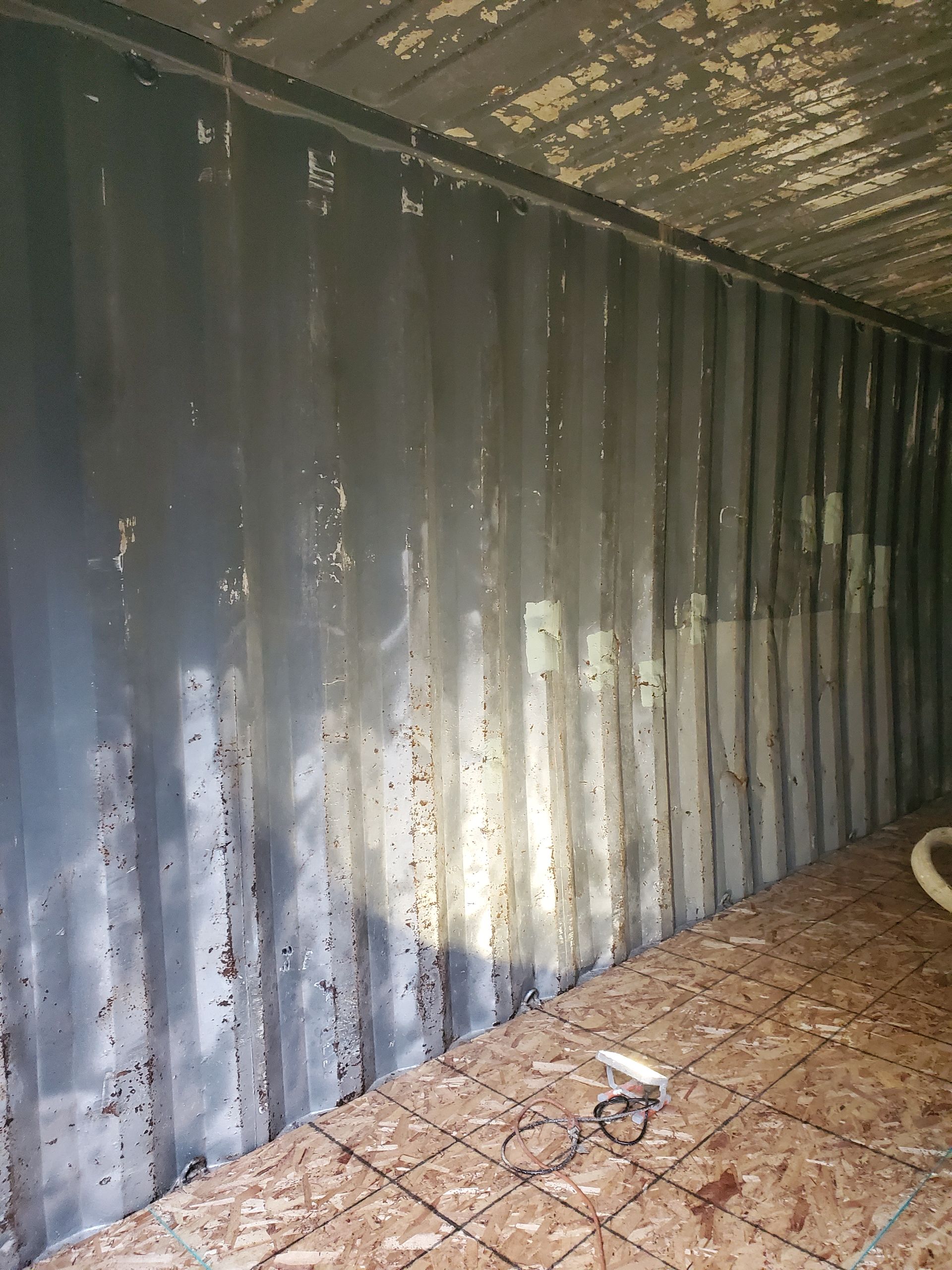 A shipping container with a hose attached to the side of it.