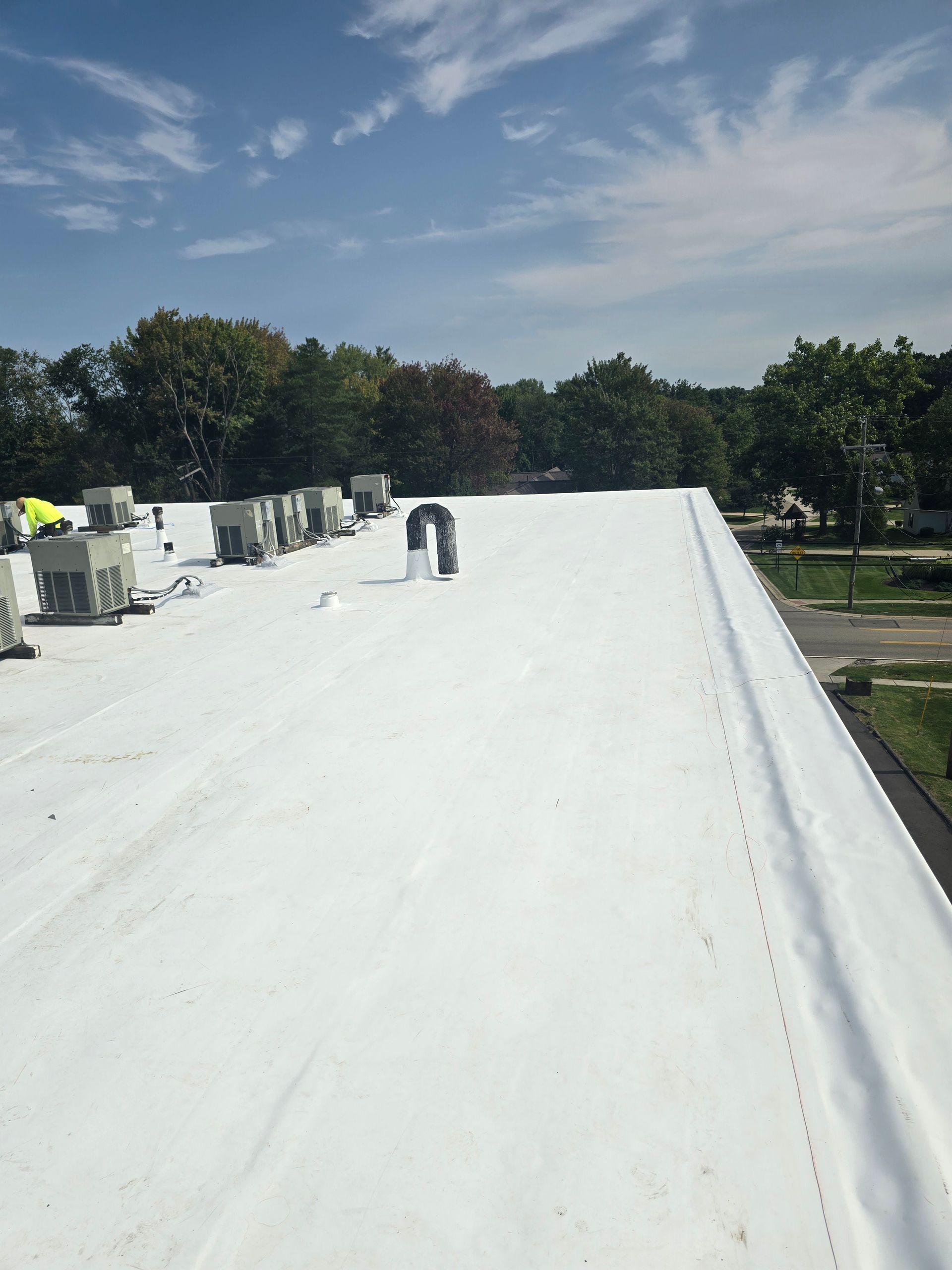 A white roof with a lot of air conditioners on it.