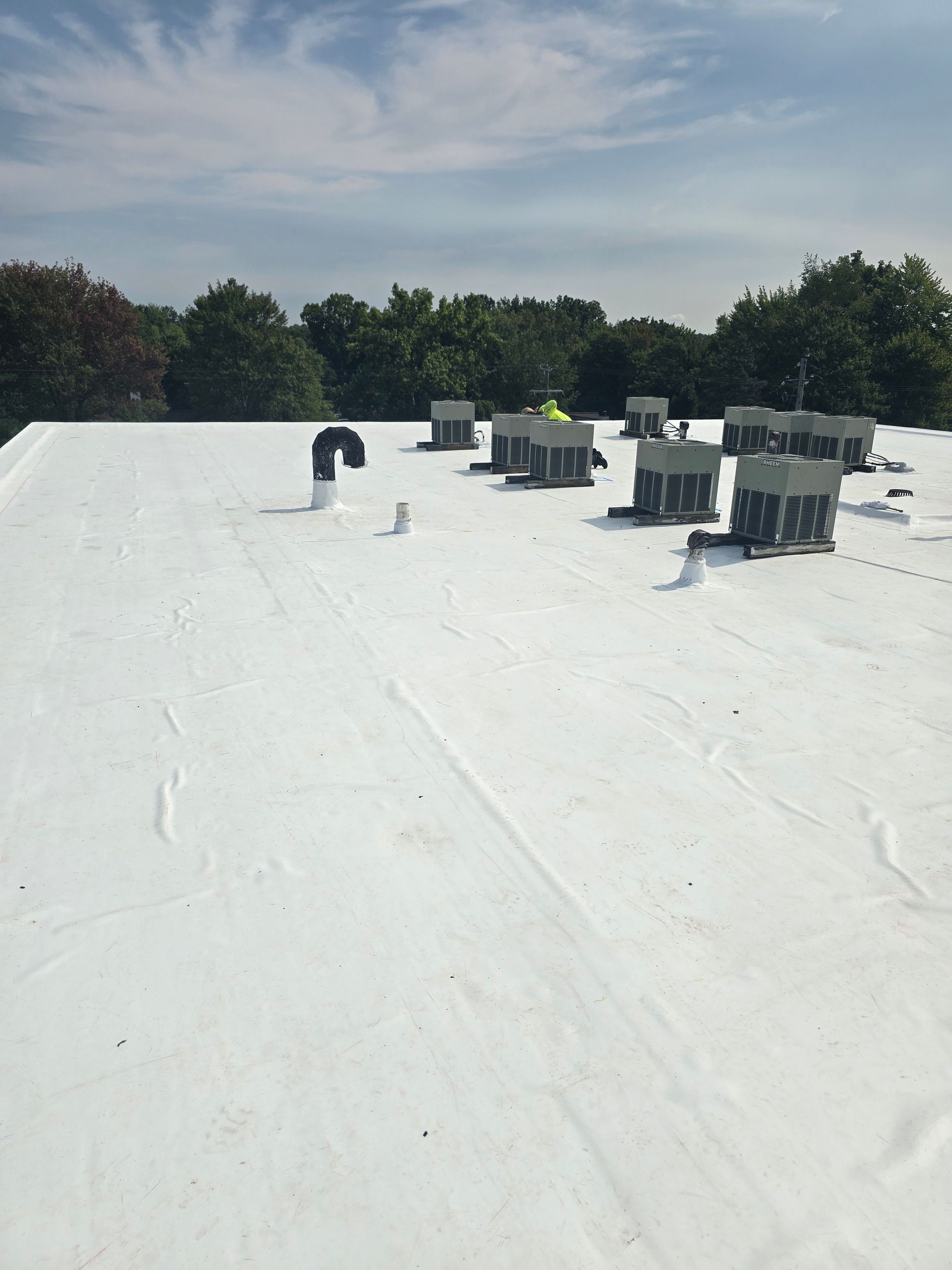 A white roof with a lot of chimneys on it.