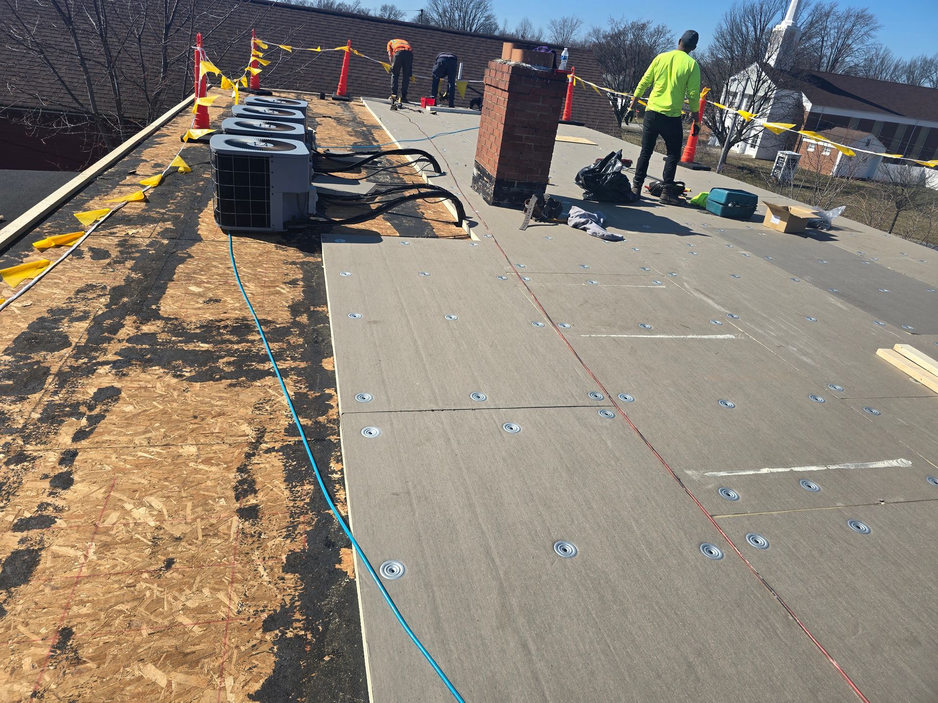 A group of people are working on the roof of a building.