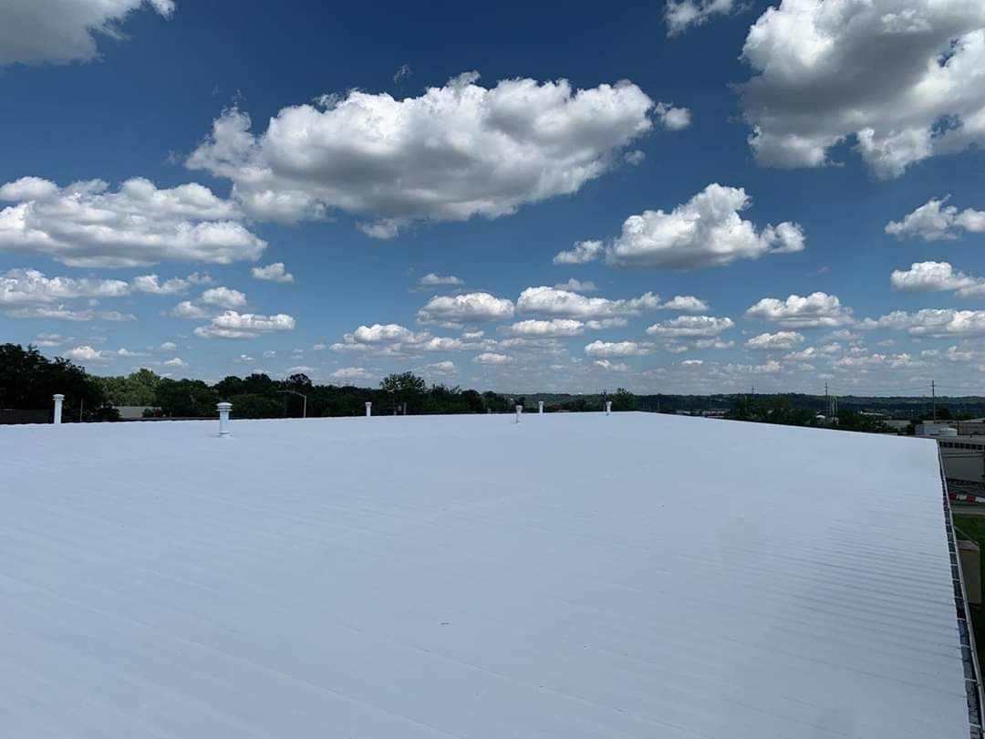 A white roof with a blue sky and clouds in the background.