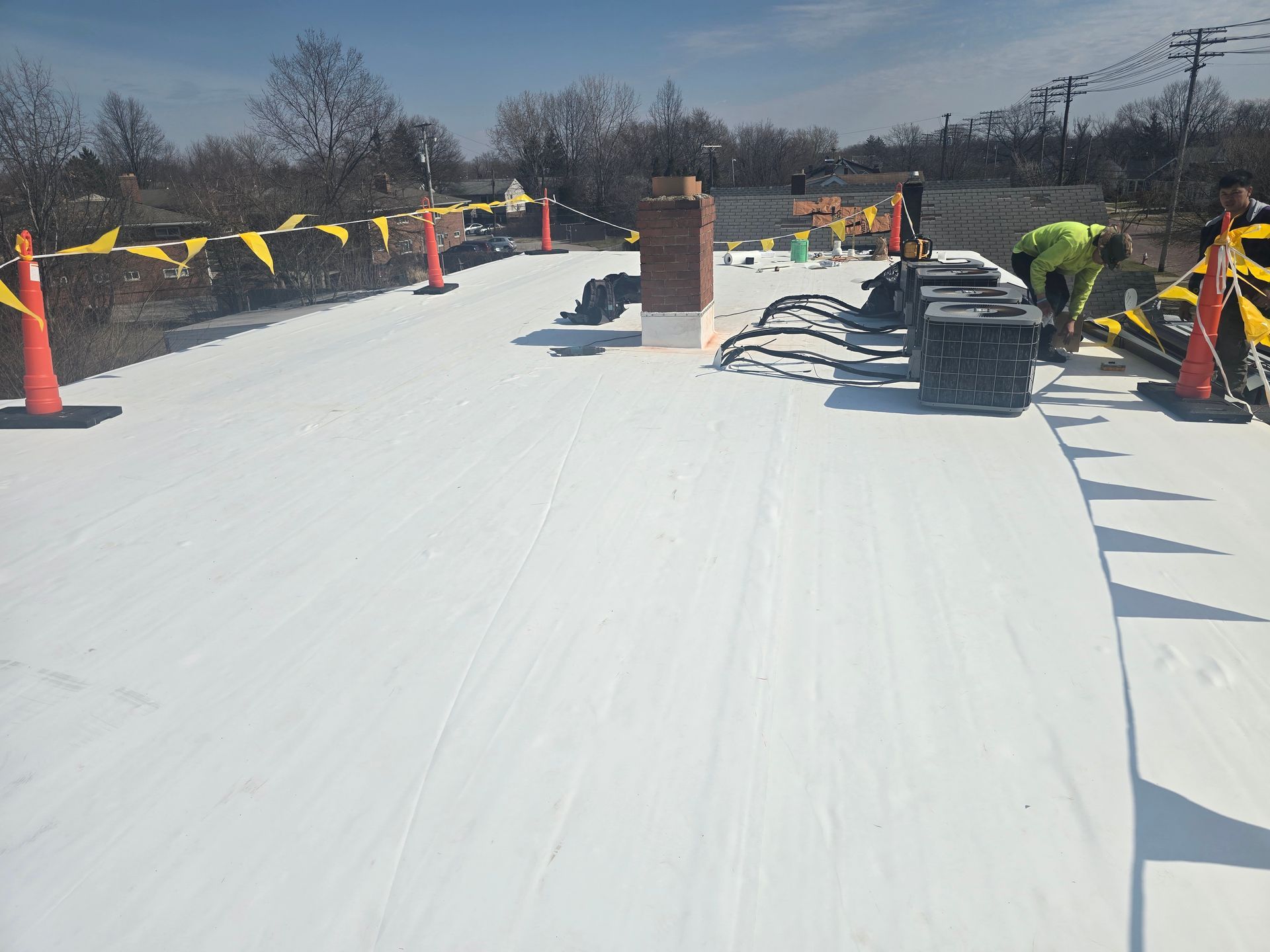 A man is working on a white roof.