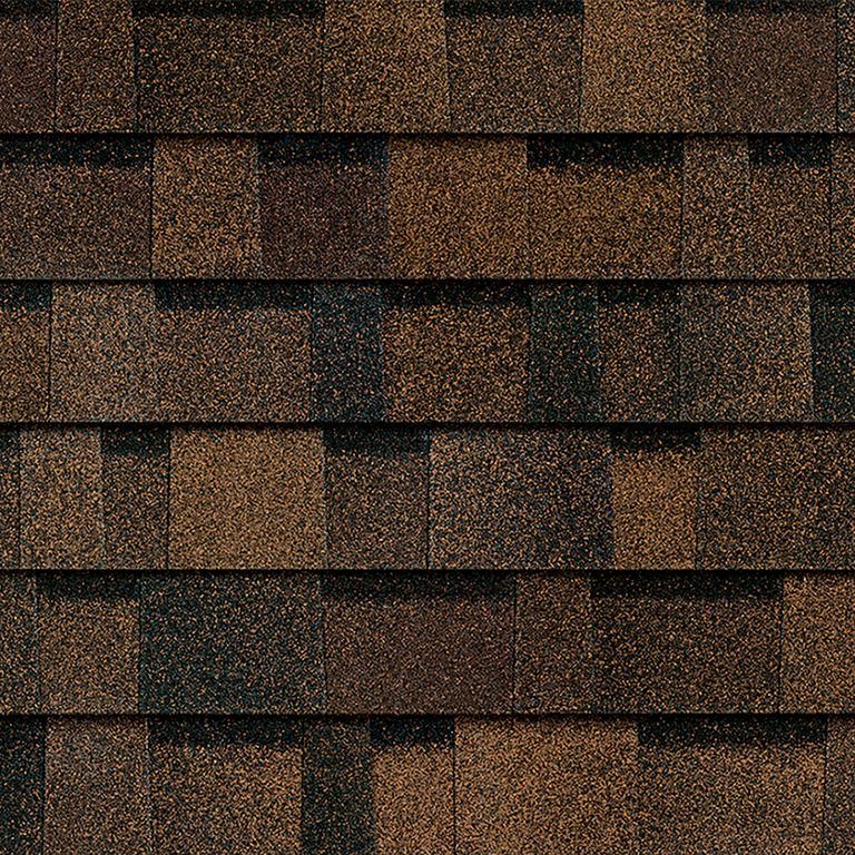 A close up of a roof with brown and black shingles.