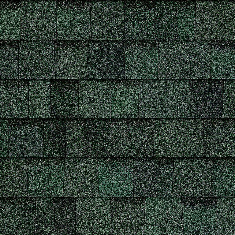A close up of a row of green shingles on a roof.