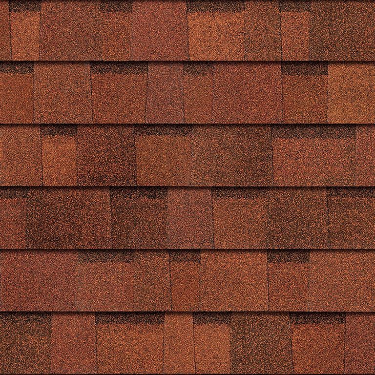 A close up of a row of red shingles on a roof.