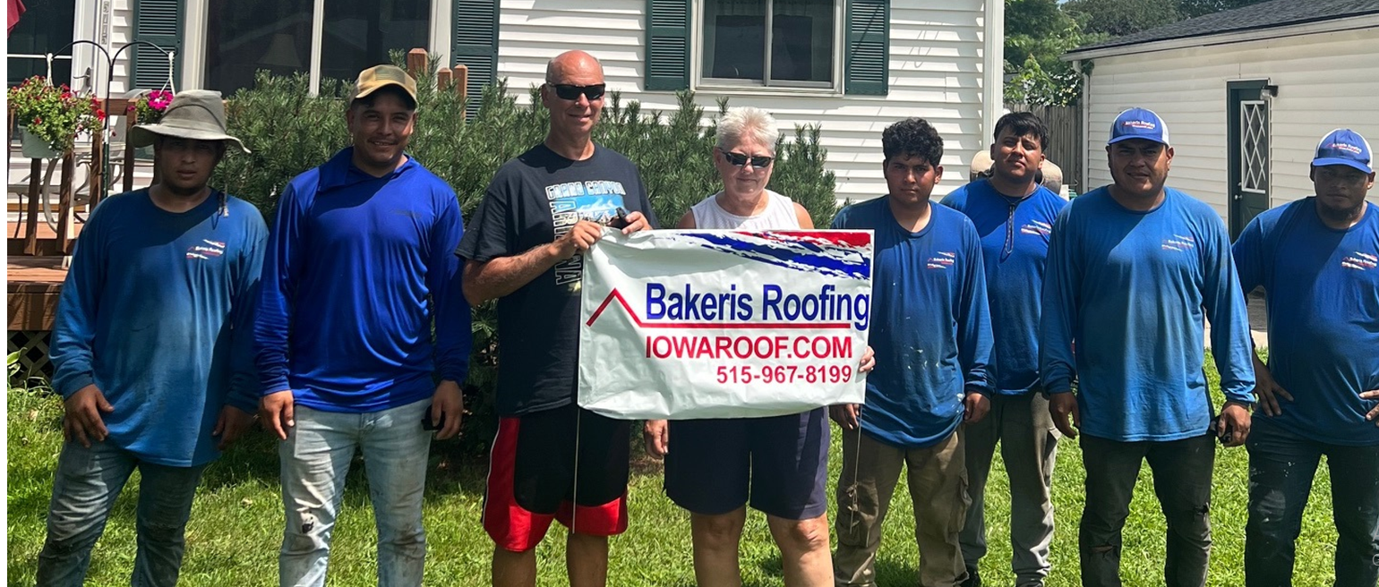 A group of people standing in front of a house holding a sign