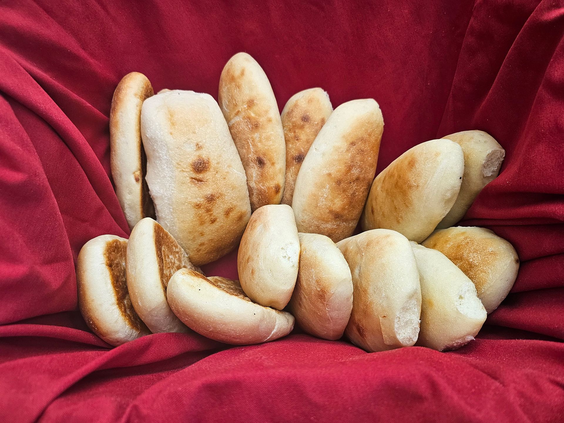 A bunch of bread is sitting on a red cloth