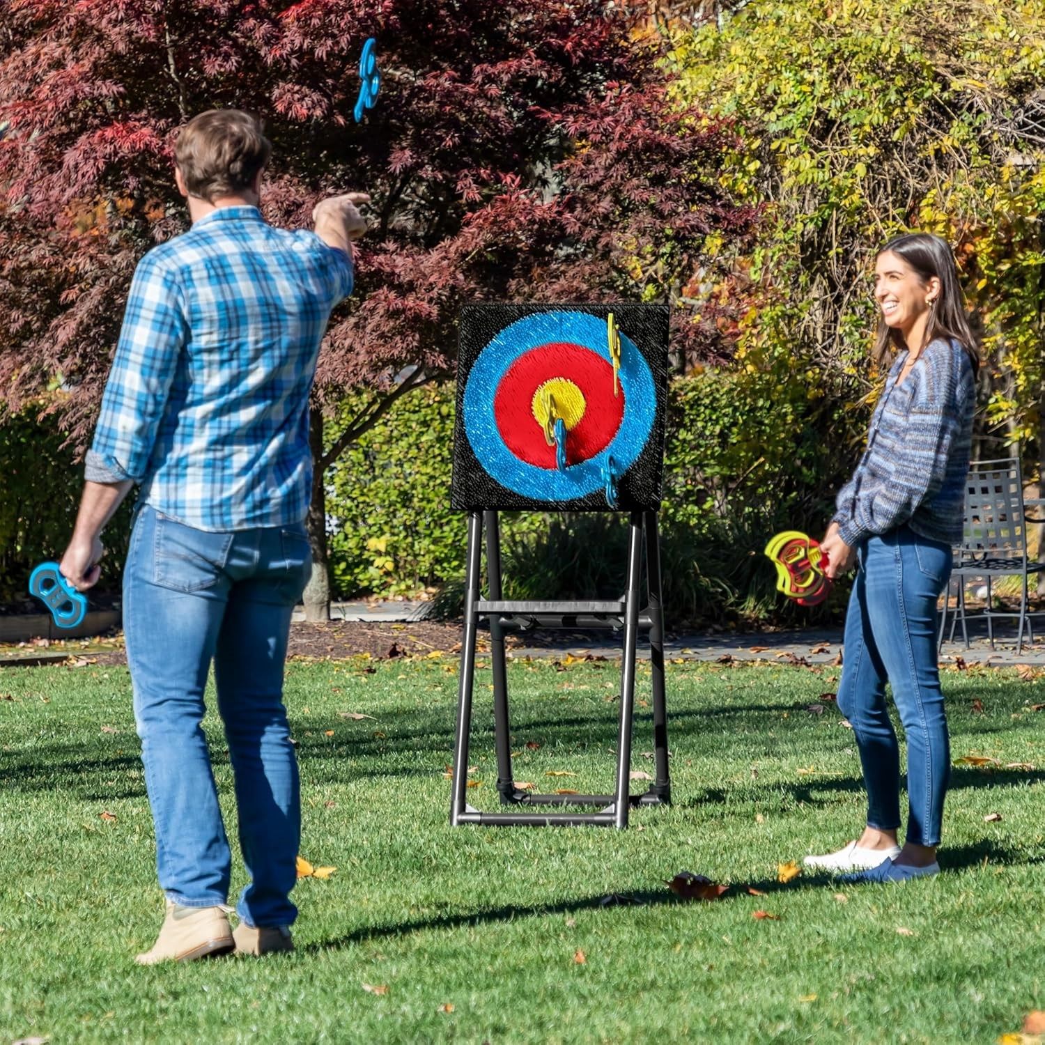 A man and a woman are playing archery in a park.