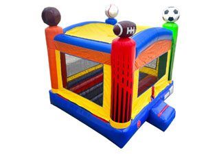 A colorful bouncy house with a football , baseball , and soccer ball on top