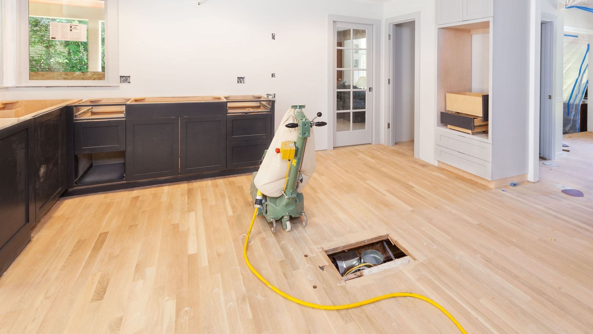 Empty room with hardwood floor, large windows, and white walls.