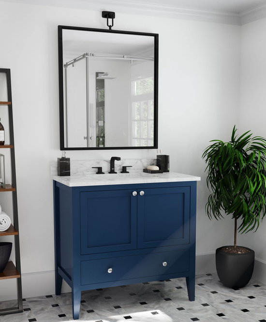 Modern bathroom with navy vanity, black mirror, white tile floor, and a potted plant