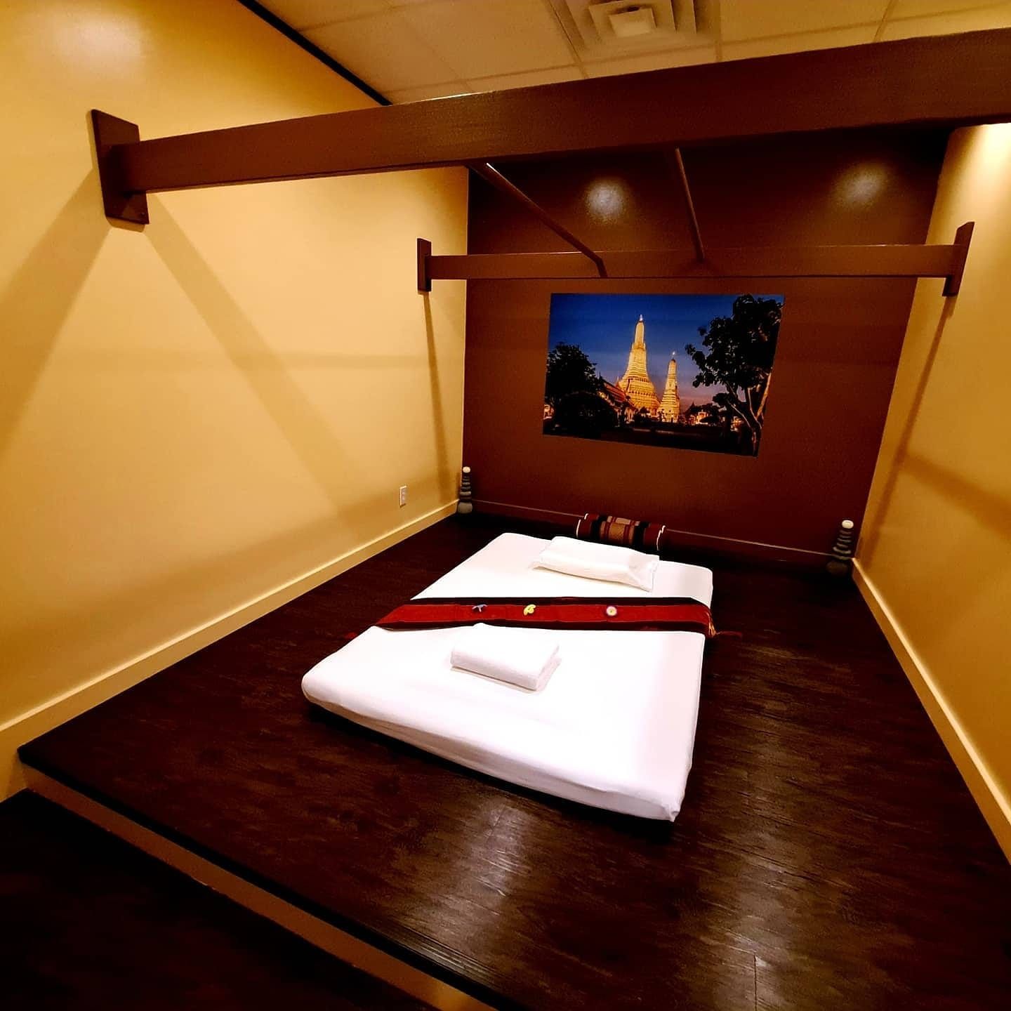 A bed with a picture on the wall above it