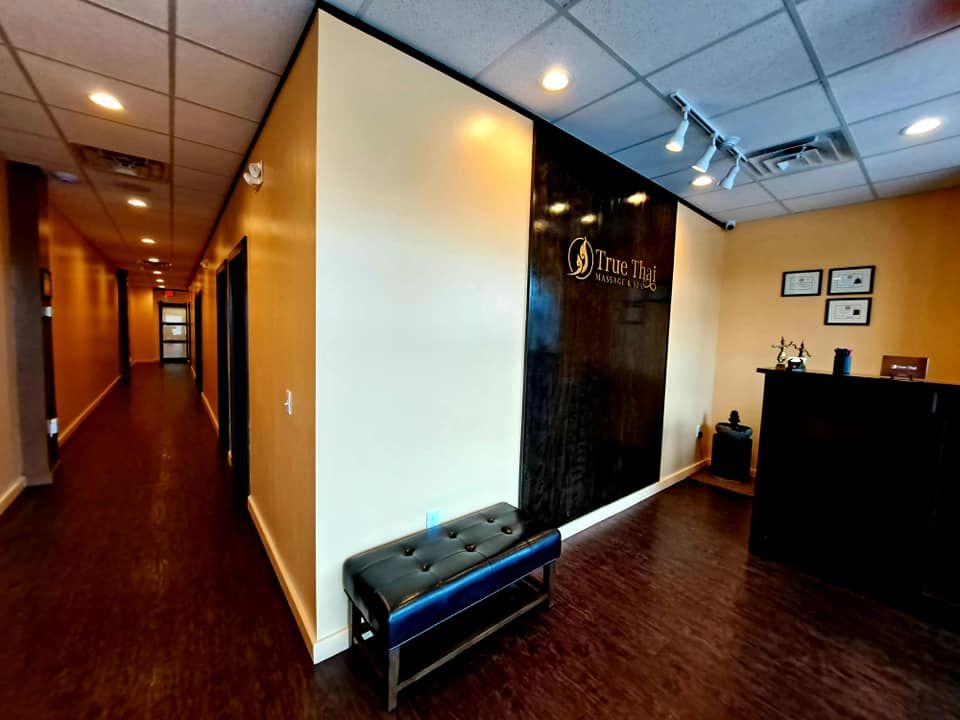 A long hallway with a blue bench in the middle of it.