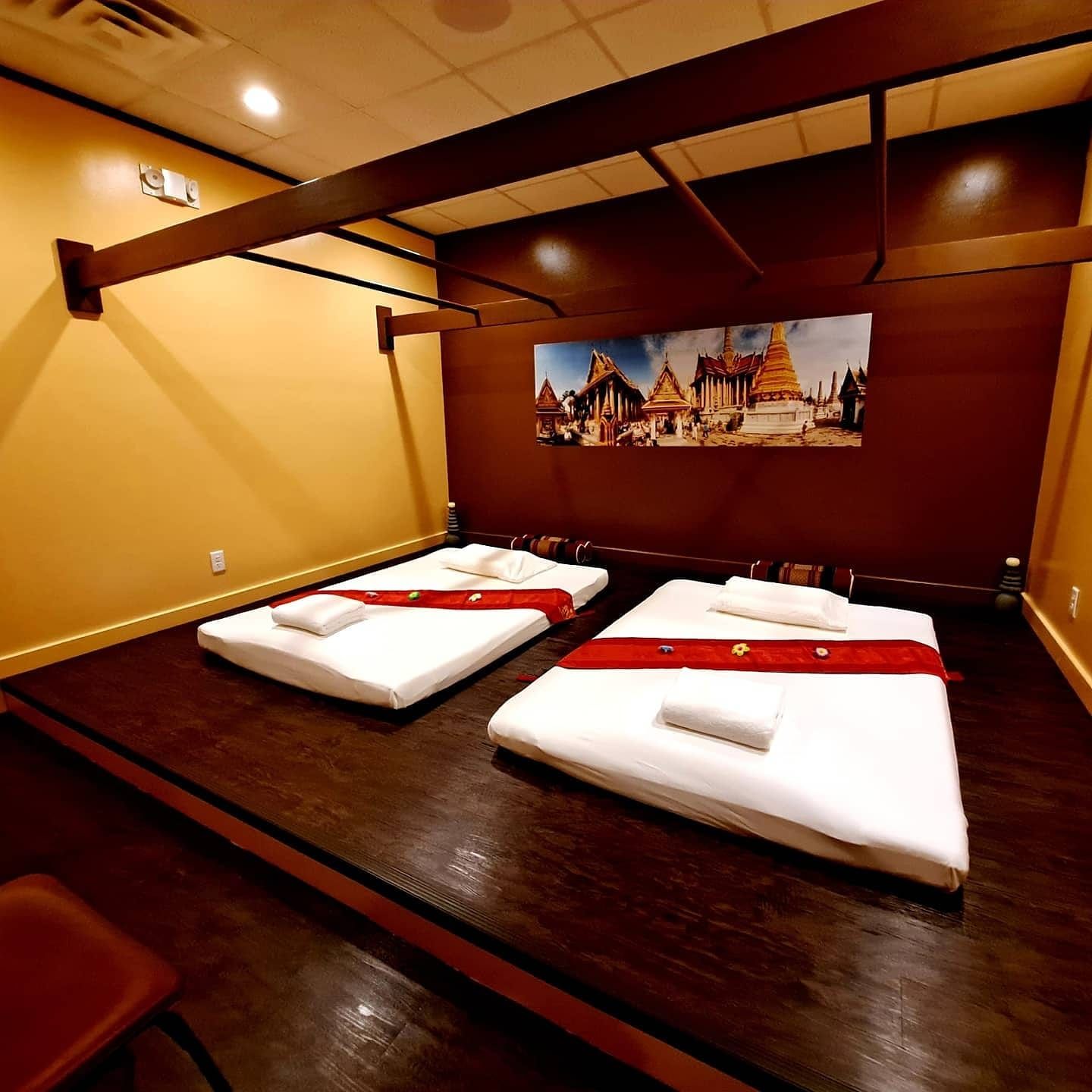 Two beds in a room with a picture on the wall above them