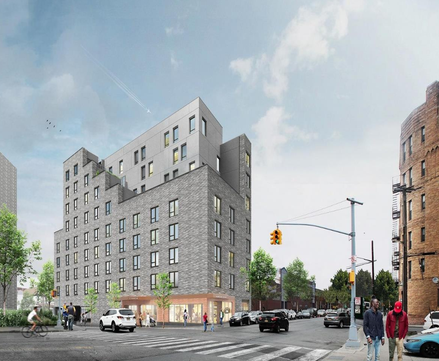 Modern gray apartment building at a city intersection with cars, pedestrians, and a traffic light