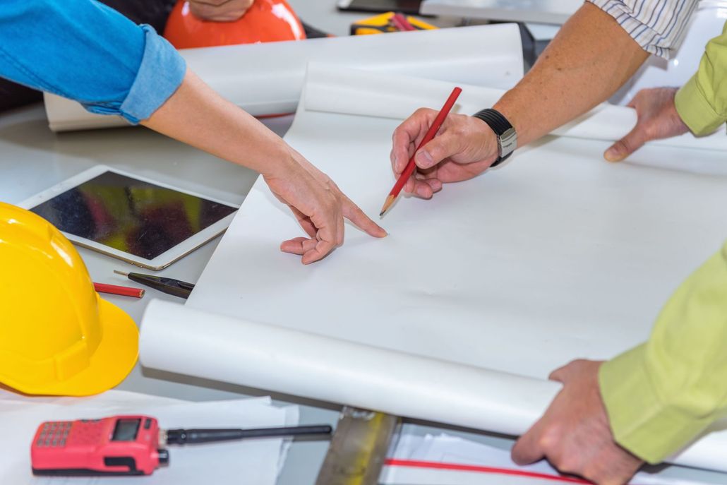 Rolled architectural blueprints resting on construction plans and technical drawings