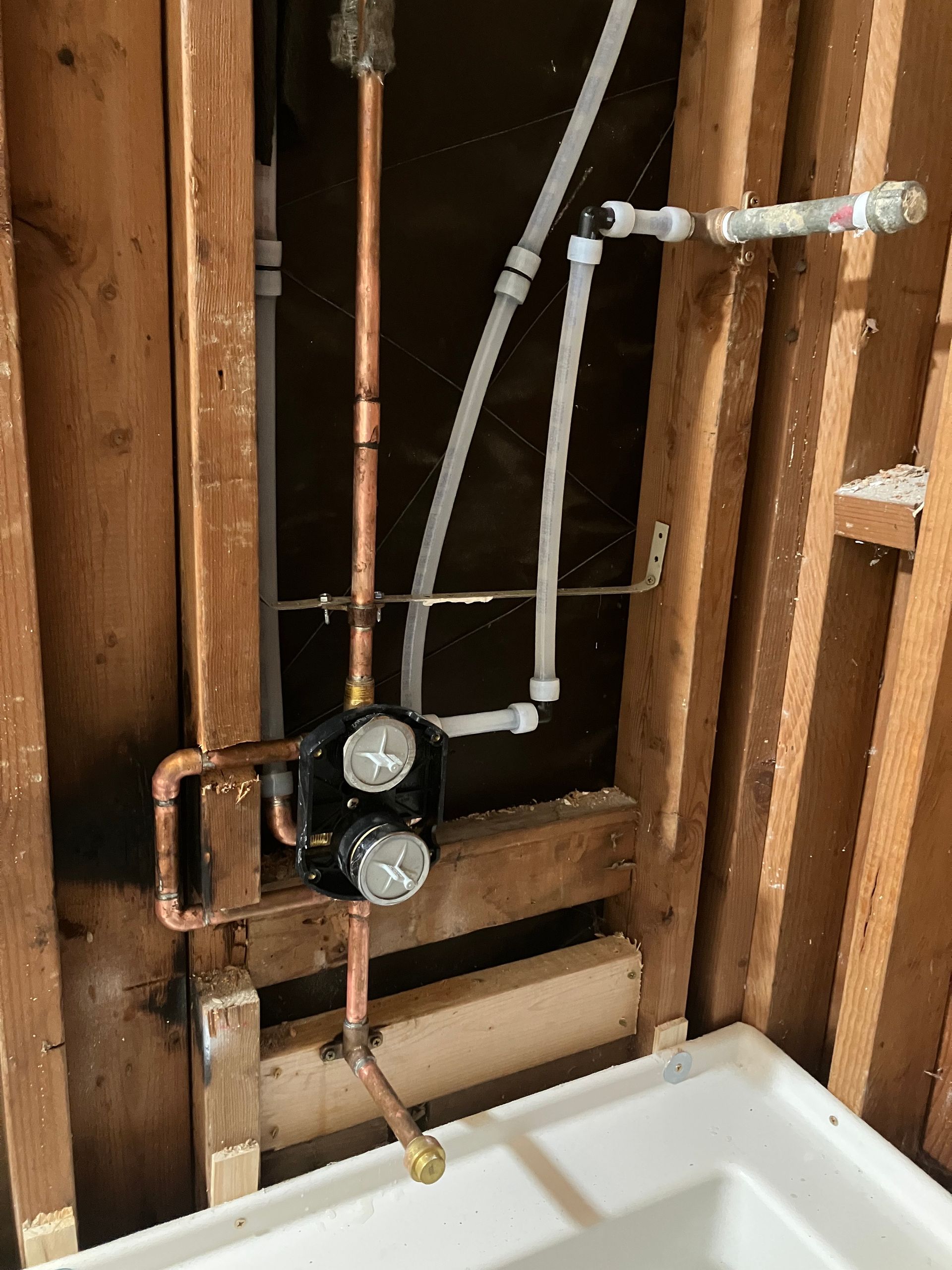 A bathroom with copper pipes coming out of the wall
