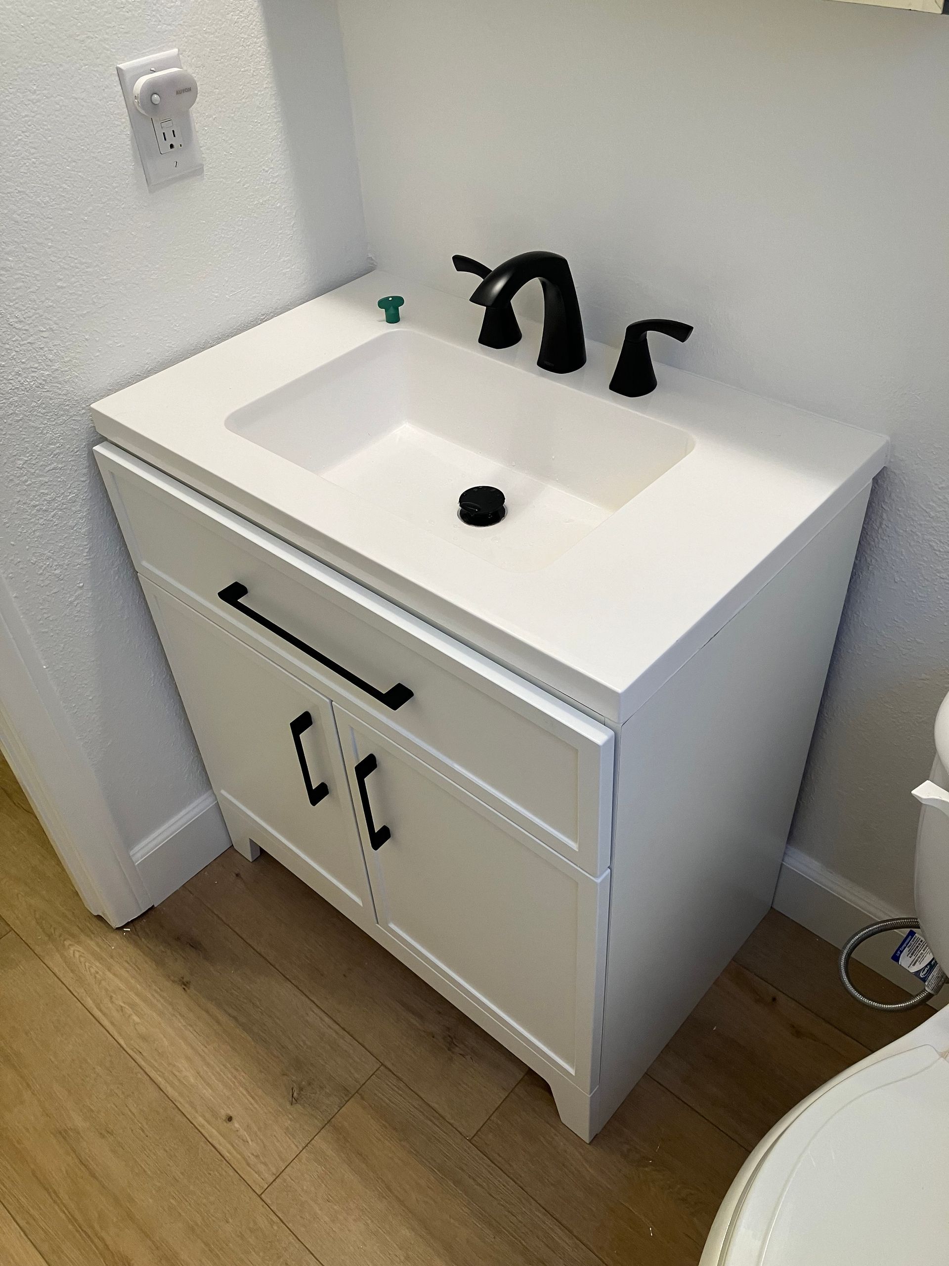 A bathroom vanity with a sink and a toilet.