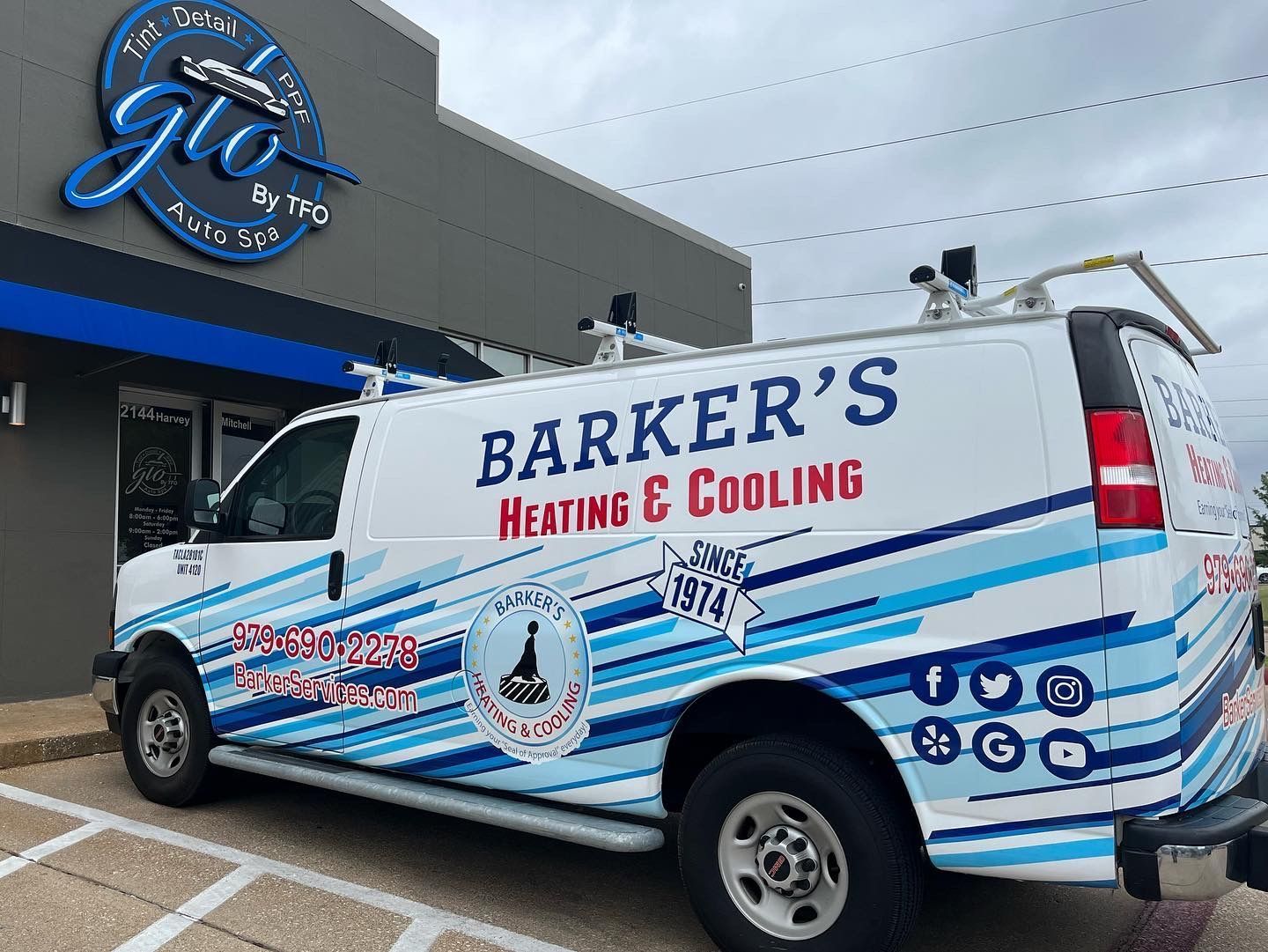 a barker 's heating and cooling van is parked in front of a building.