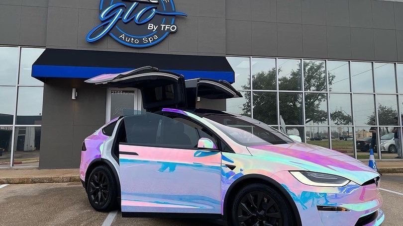 A Tesla Model X is parked in front of a building.