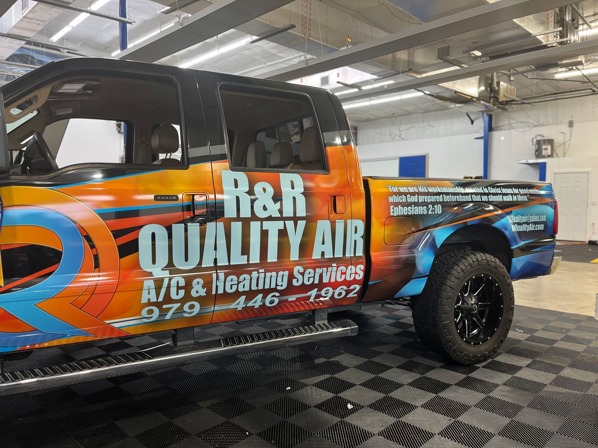 a truck with a wrap on it is parked in a garage.