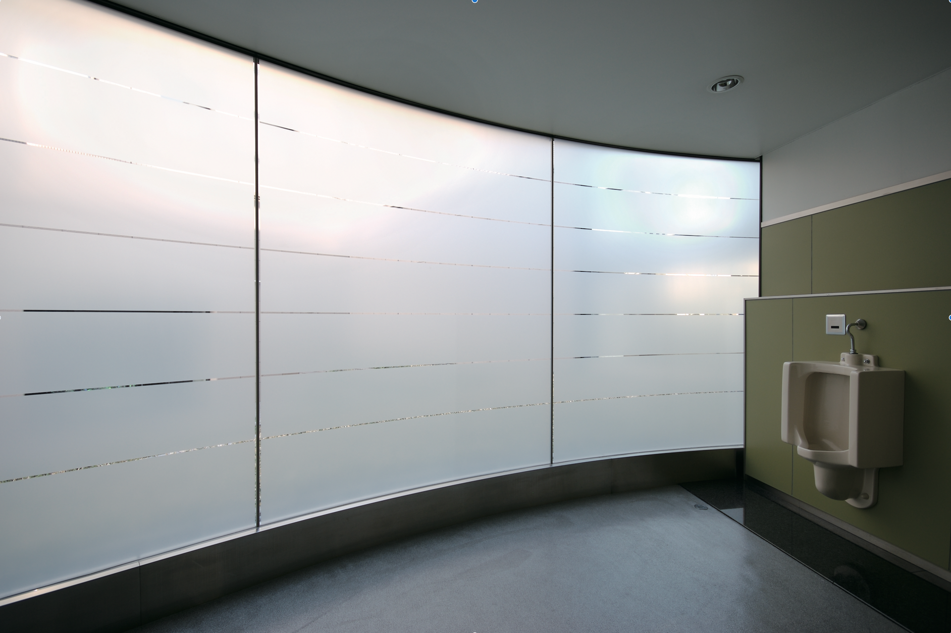 A bathroom with a urinal and a large window