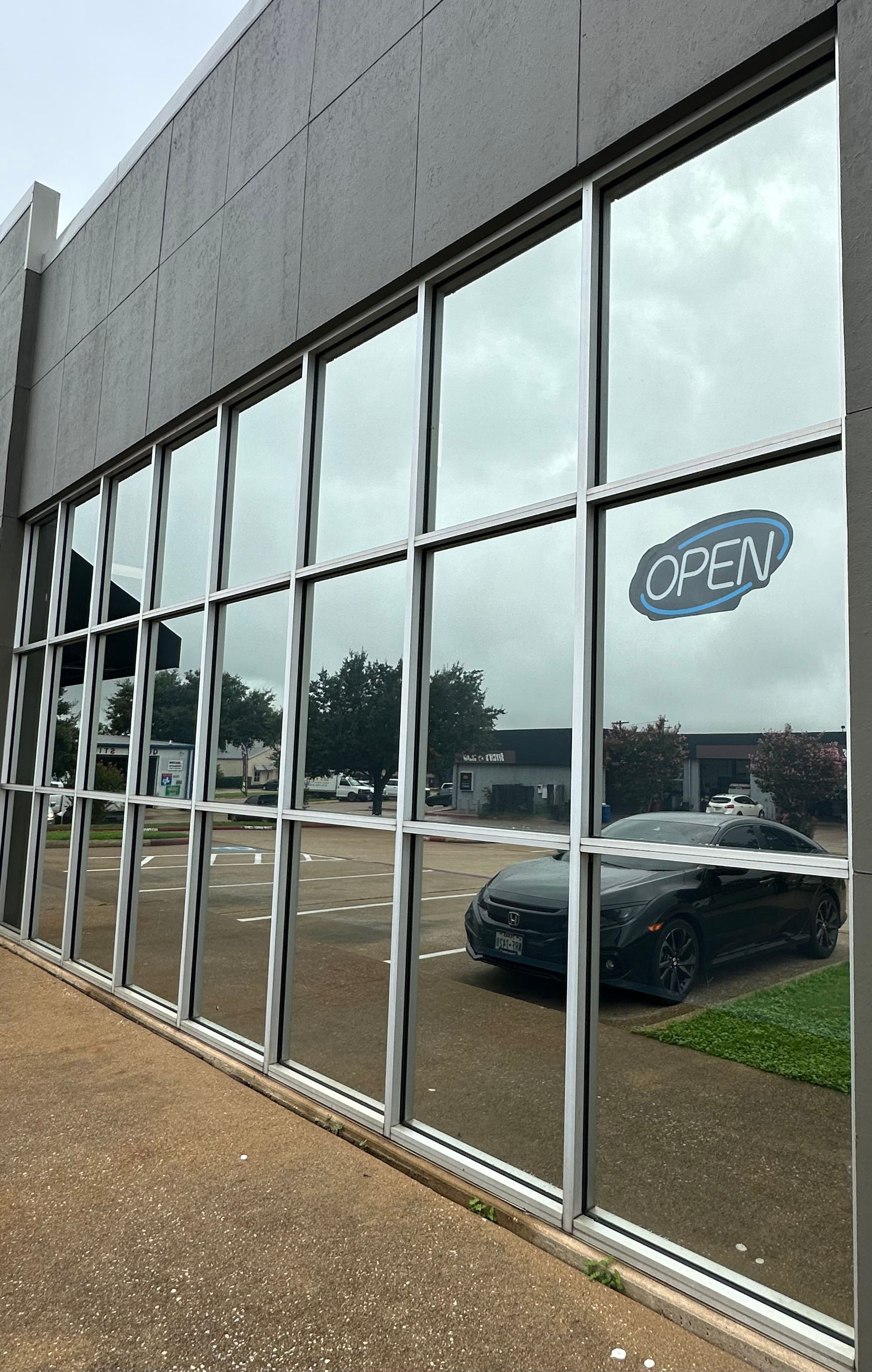 A car is reflected in the windows of a building.