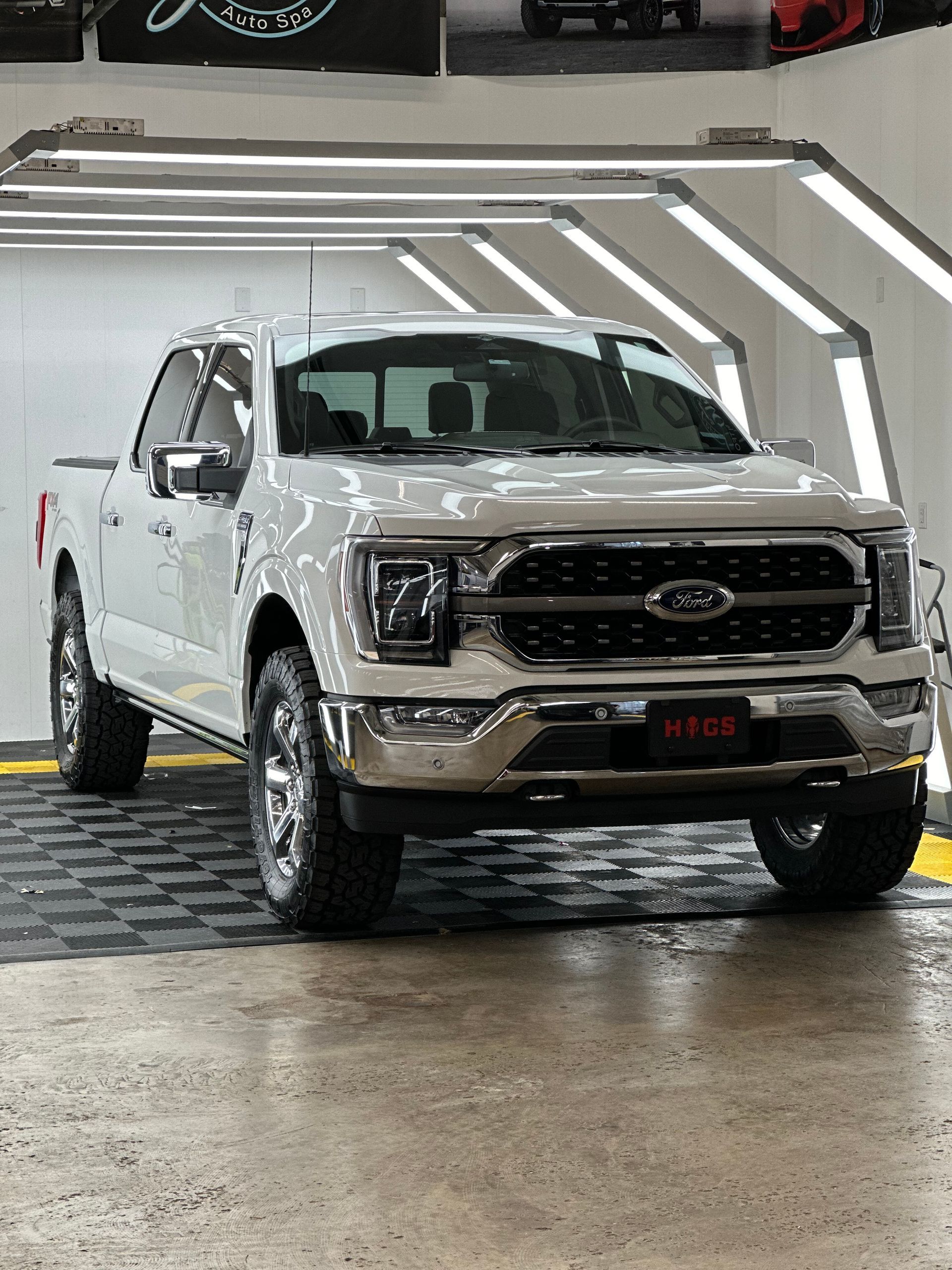 a white ford f150 is parked in a car wash .