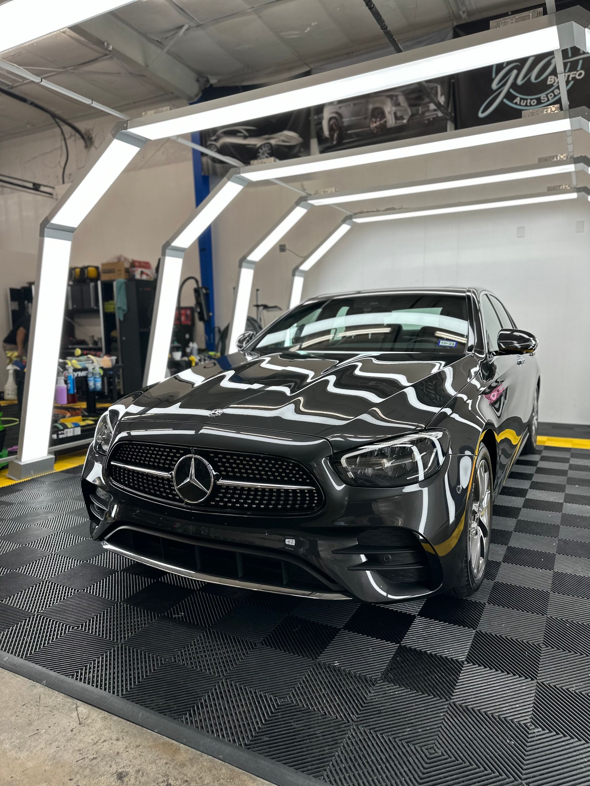 a black mercedes benz is parked in a garage .