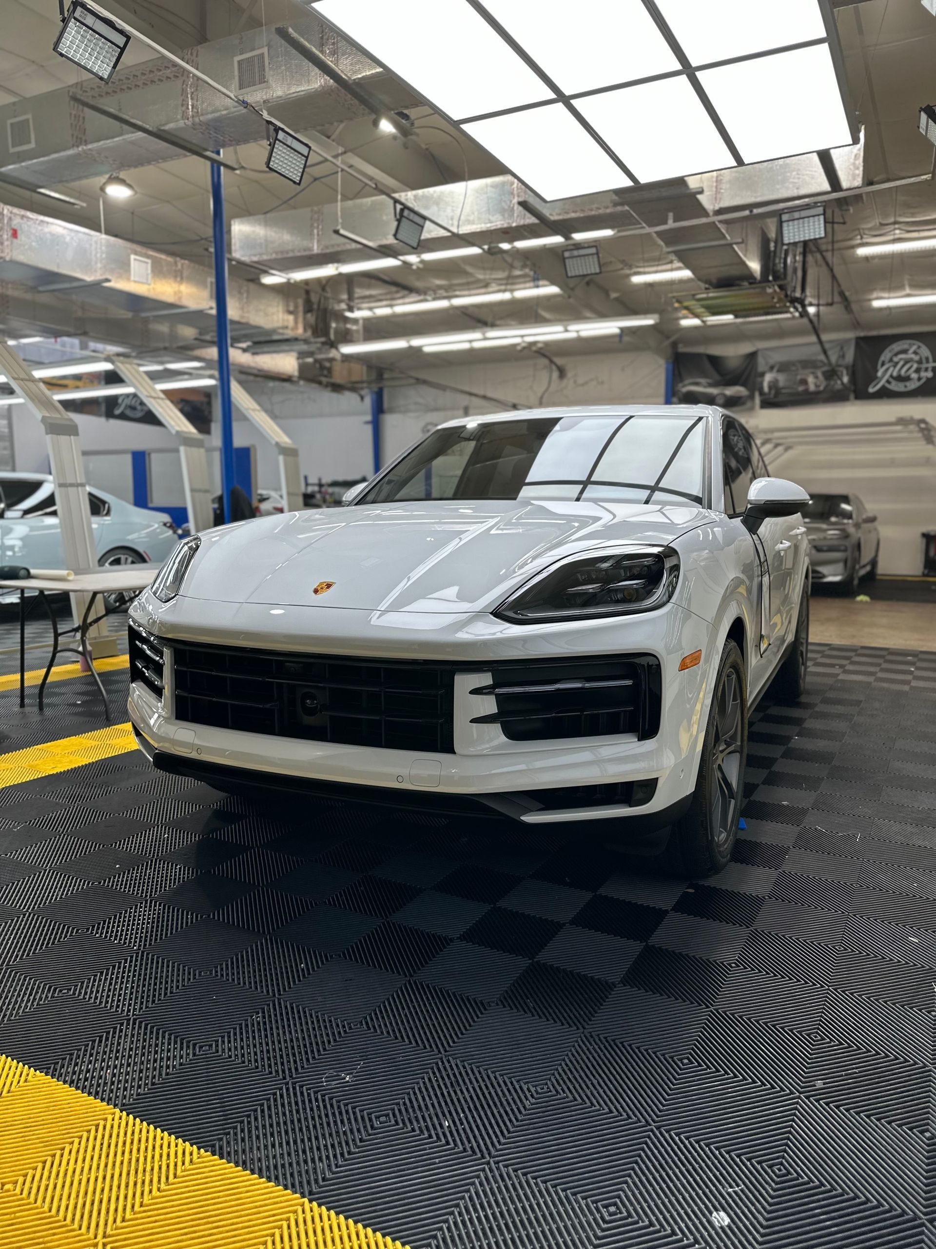 a white porsche cayenne turbo is parked in a garage .
