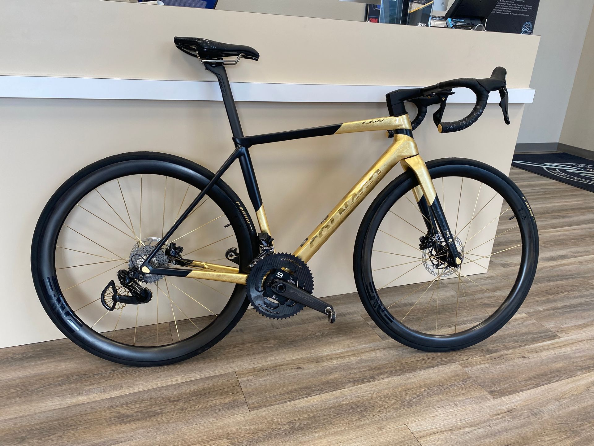 a black and gold bicycle is parked on a wooden floor .