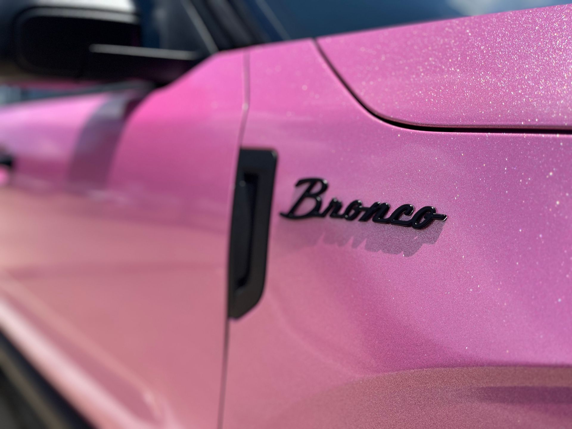 a close up of the side of a pink bronco